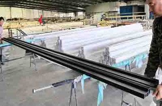 Quality control team inspecting finished FRP profiles at the factory