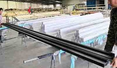 Quality control team inspecting finished FRP profiles at the factory