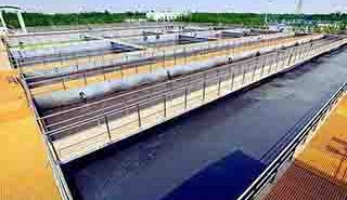 FRP plant access flooring with drainage covers and corrosion-resistant infrastructure supports at a water treatment facility.