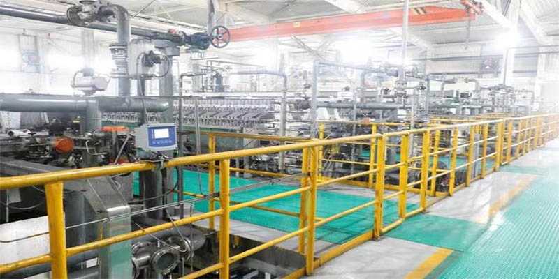 FRP solid top checker plate grating walkway and platform with yellow handrails in a food and beverage processing facility, illustrating cleanable continuous surfaces and traction features.